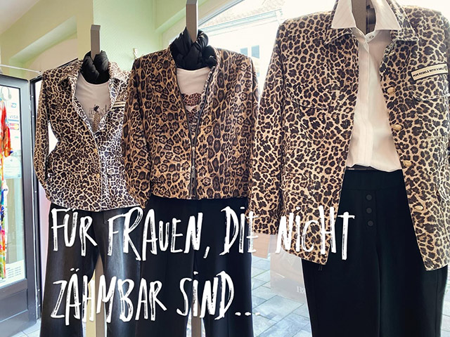 Drei Schaufensterpuppen in Leopardjacken mit schwarzer Hose, ein weißes Hemd.