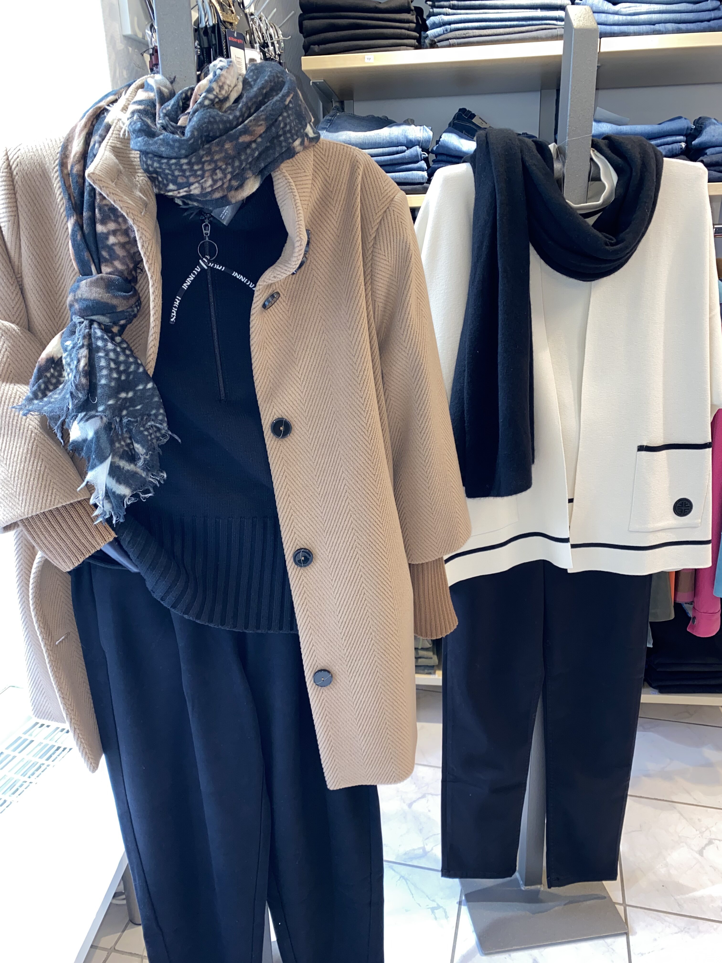 Zwei stilvolle Schaufensterpuppen tragen elegante Herbstmode in Beige und Schwarz