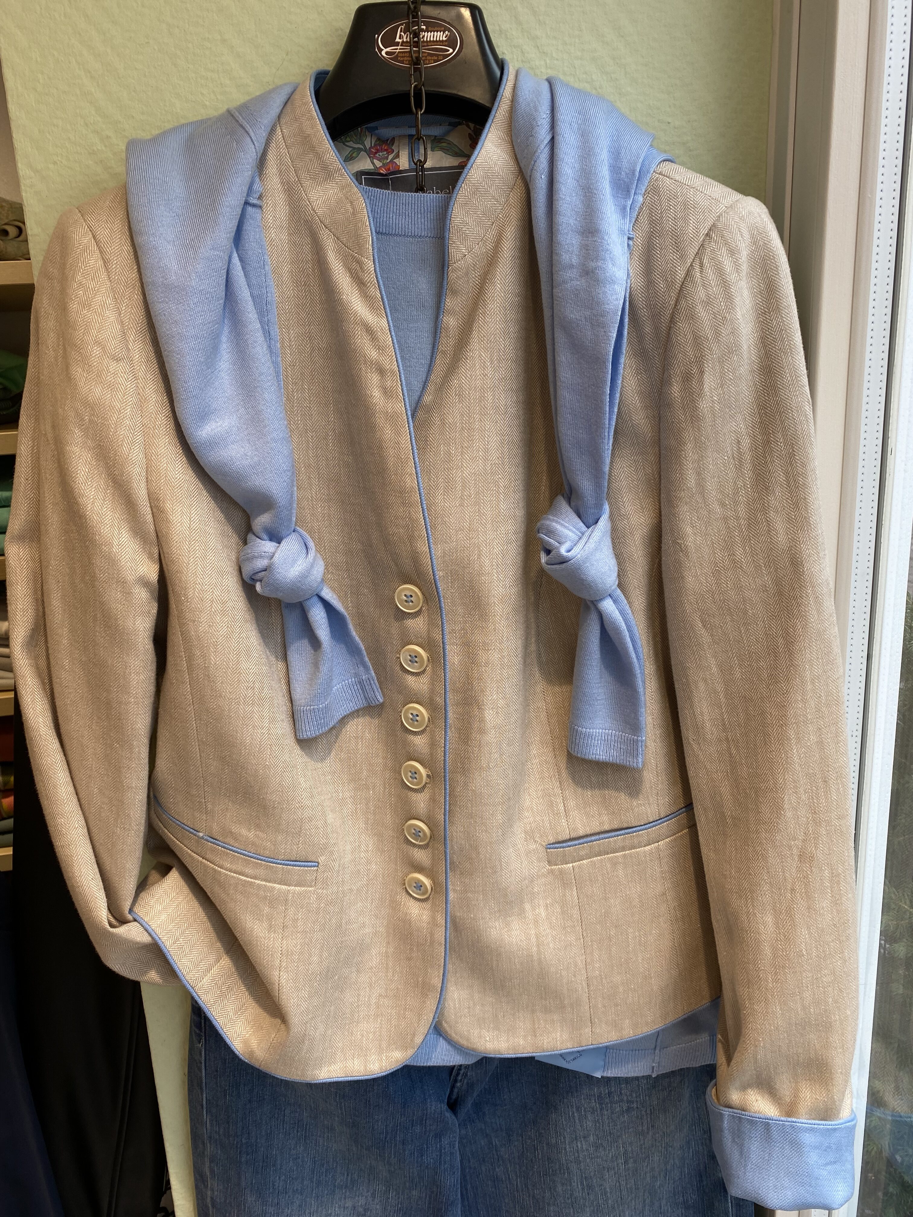 Beige Sakko mit blauer Strickjacke darüber, kombiniert mit einer blauen Hose