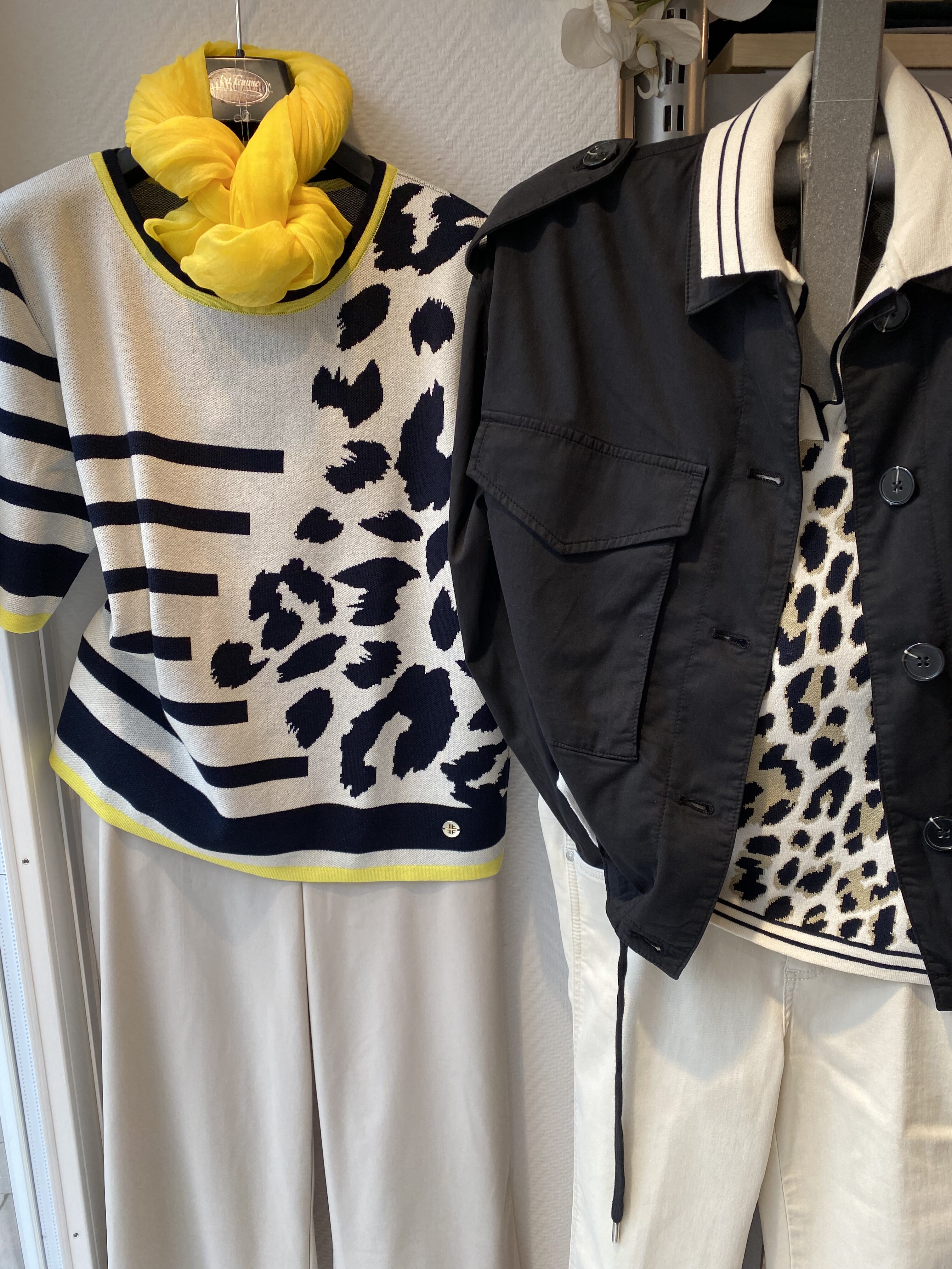 Zwei Schaufensterpuppen tragen Outfits mit auffälligem Leopardenmuster und gelben Akzenten