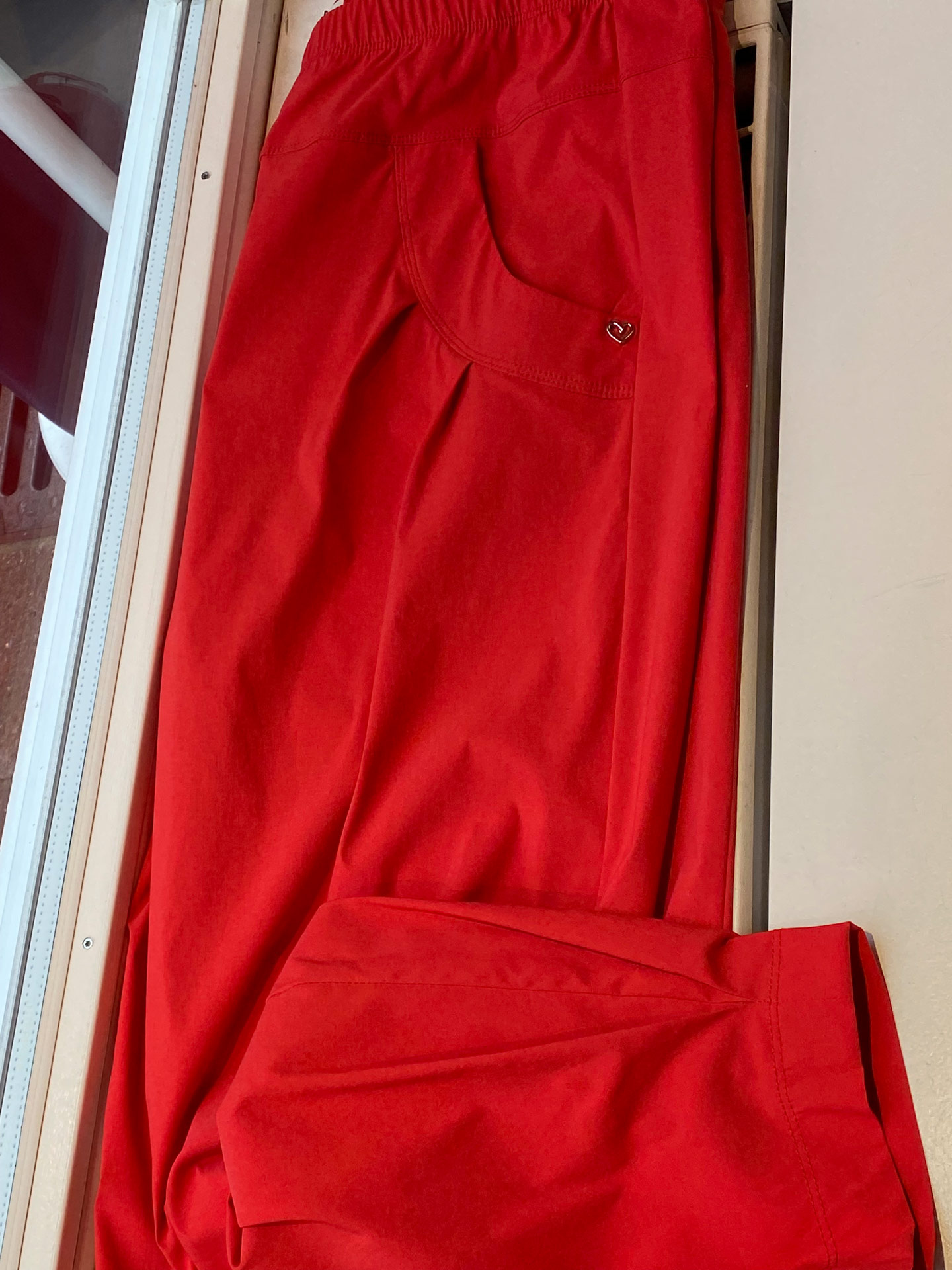 Rote Hose ohne Person, glatt, mit Seitentasche und Gummibund gezeigt