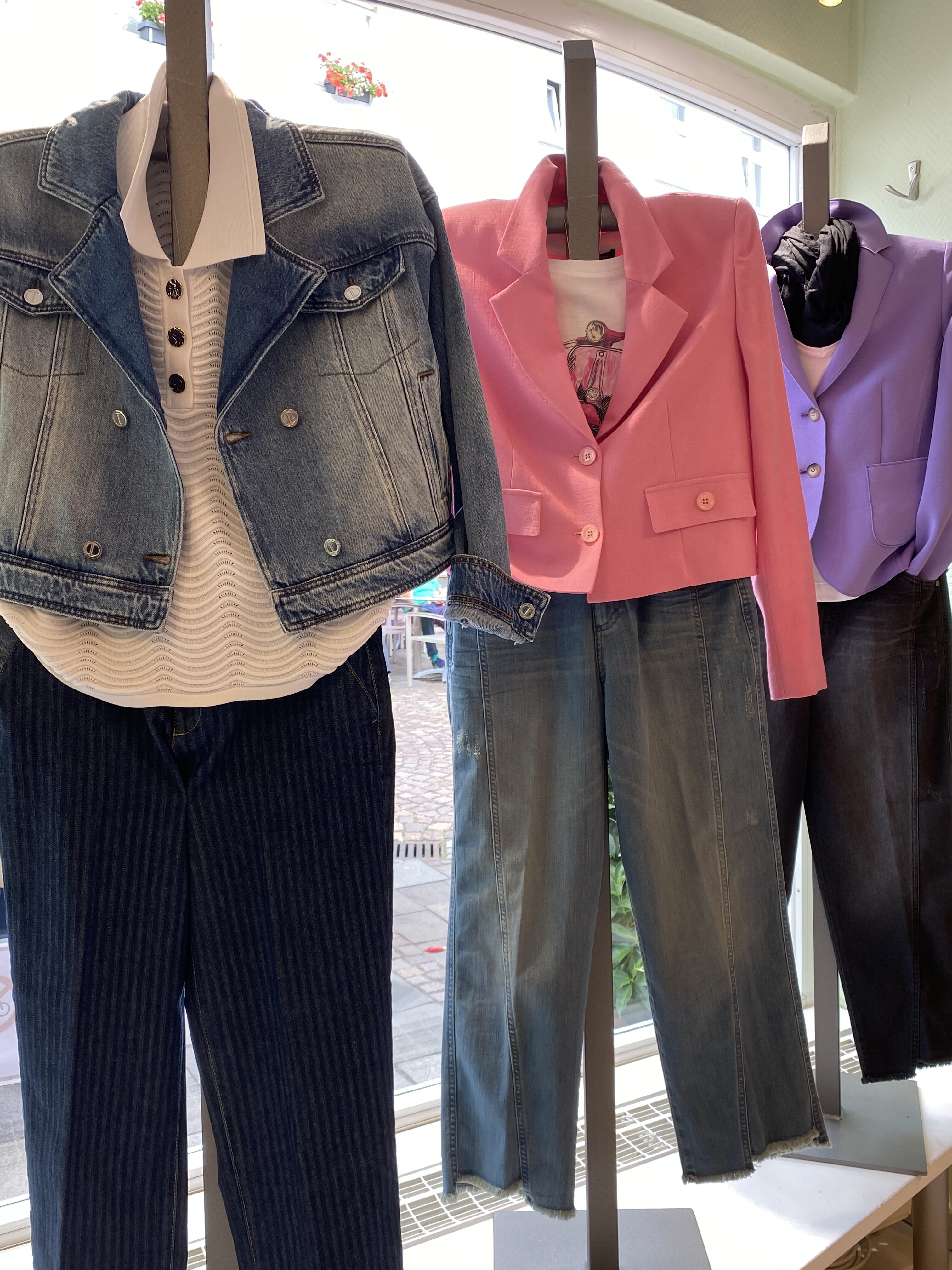 Drei Outfits im Schaufenster mit Jeansjacke rosa und lila Blazer zu Jeans