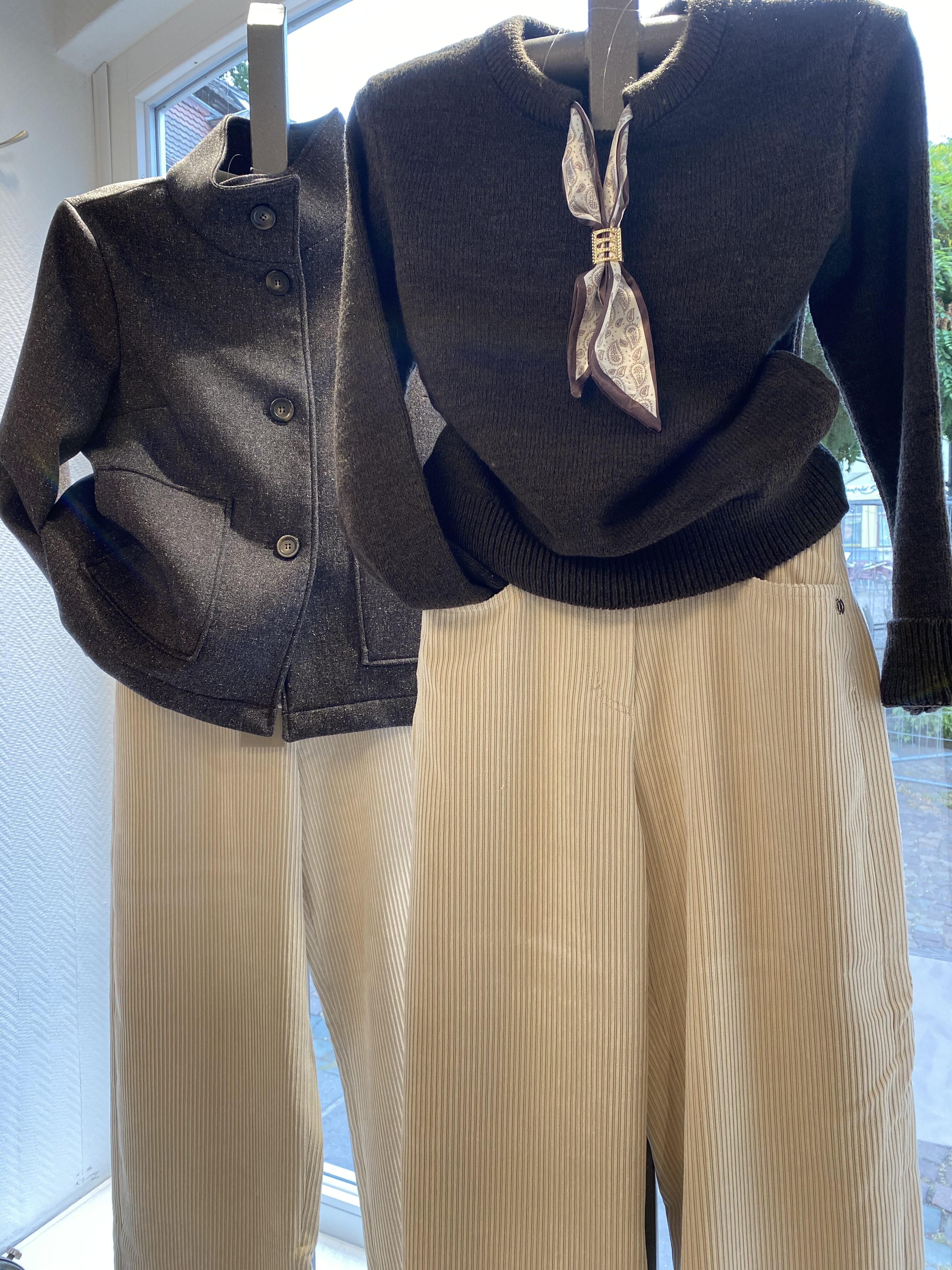 Zwei Outfits mit dunklen Oberteilen beigen Cordhosen und einem Seidentuch