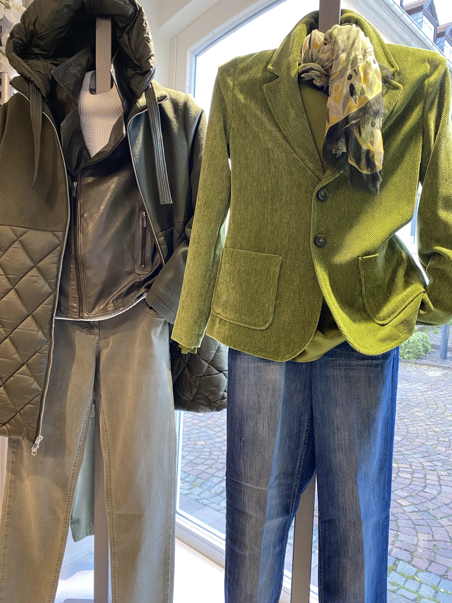 Zwei Schaufensterpuppen in gruenem Blazer und olivfarbener Jacke mit Jeans